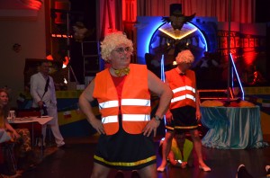Das Männerballett gibt das Beste, mit Perücke und orangener Warnweste.